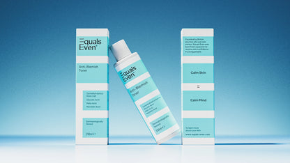 Three boxes and a bottle of Anti Blemish Toner stand on a blue surface with a gradient background. The white packaging with light blue accents highlights the liquid exfoliation that unclogs pores for glowing skin.