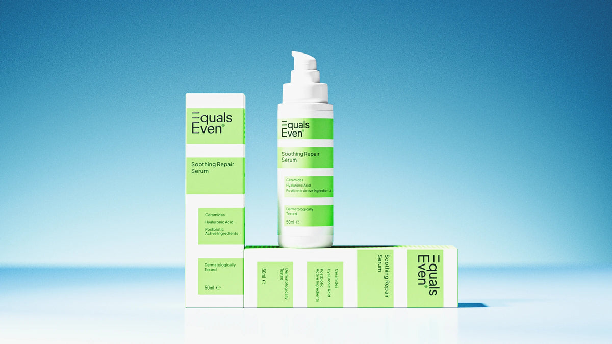 Three units of Soothing Repair Serum—one bottle and two boxes—are shown against a blue background. The white and green packaging highlights ceramides, hyaluronic acid, and its calming effect on stressed skin.