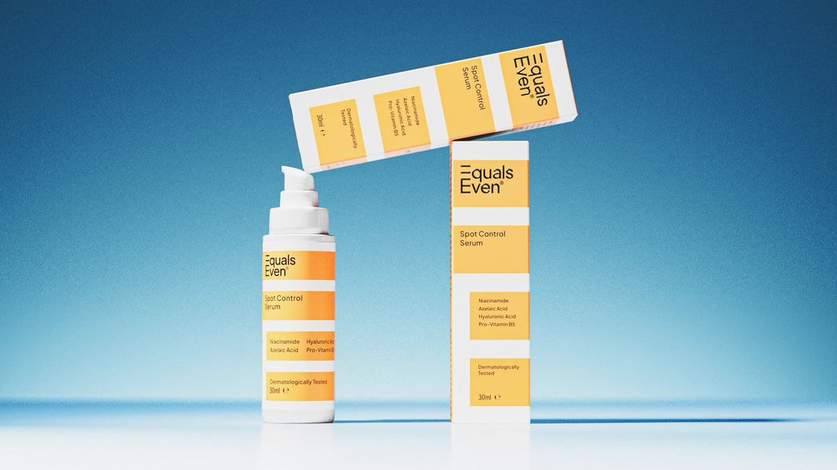 Three Spot Control Serum bottles and boxes are displayed against a blue background. The white and yellow packaging highlights this blemish serum, which helps fade post-blemish marks for smoother skin. Two boxes stand upright, others lie horizontally on top.
